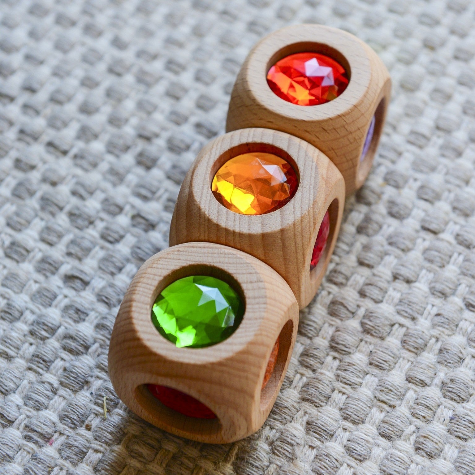 Ein Kind sortiert bunte Holzklötze in runde Schalen auf einem Brett. Ein hands-on Farbzuordnungsspiel. Perfekt für nachhaltige, ästhetische Lernspielzeuge von KLICKKLACK.