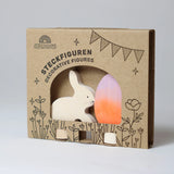 Steckfigur: Osterset Batik Orange zeigt zwei handbemalte, laser-geschnittene Holzfiguren von Grimm’s, ein Häschen und ein Osterei, in einer floral bedruckten Kartonverpackung, ideal für stilvolle Osterdekoration.