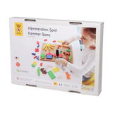 Hämmerchenspiel: Kinder spielen mit einem hölzernen Hammer, um bunte Formen auf eine kleine Korkplatte zu nageln. Hergestellt in Deutschland, fördert es Geschicklichkeit und Motorik, geeignet ab 3 Jahren. CE-zertifiziert.