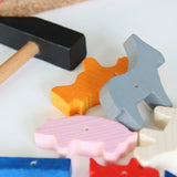 Hämmerchenspiel: Ein Spielset mit einem kleinen Hammer aus Holz mit schwarzem Kopf und bunten, tierförmigen Holzblöcken, das handwerkliches Geschick und Motorik fördert, hergestellt in Deutschland.
