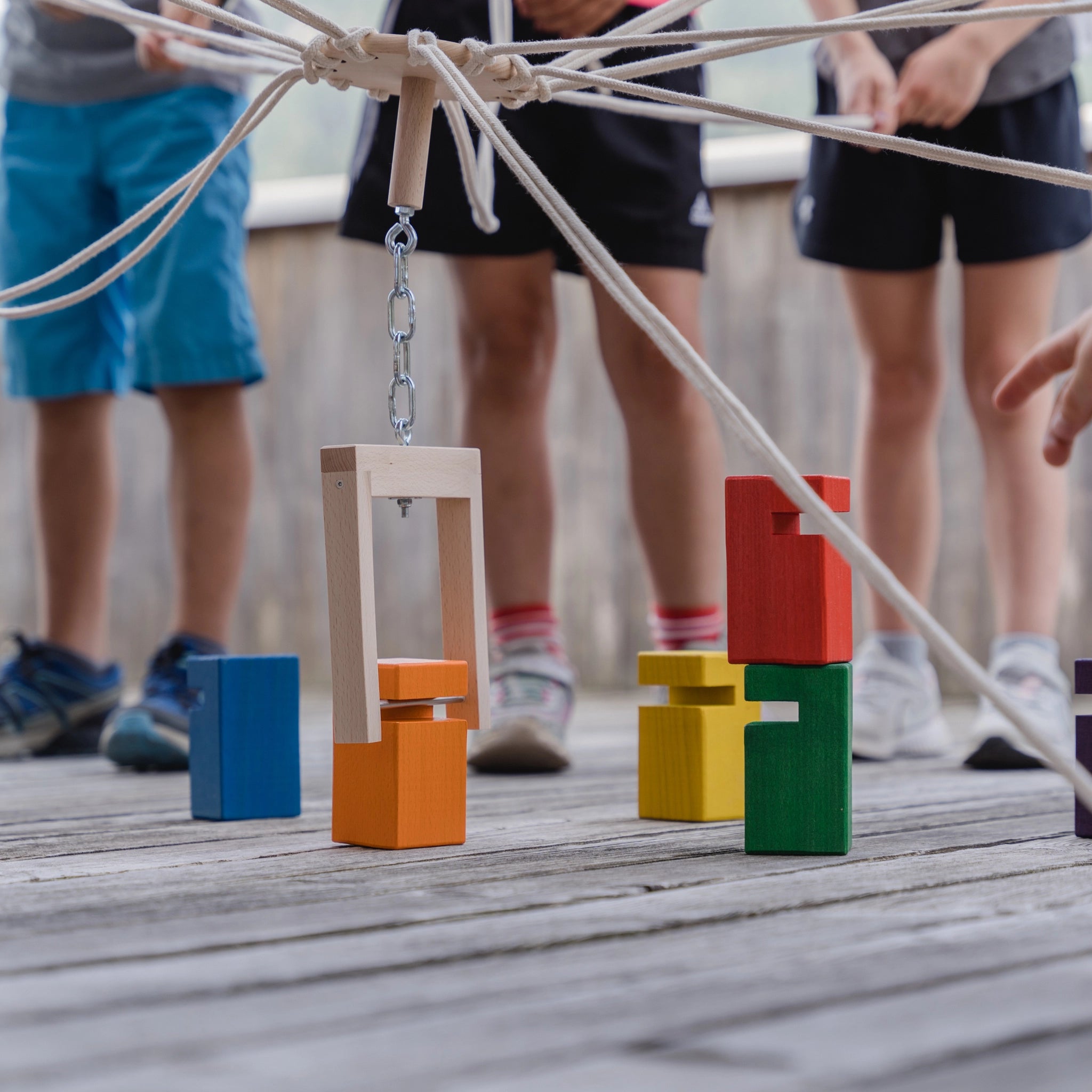 Kinder spielen mit dem Teamspiel: Kinder-Fröbelturm bunt aus Buchenholz, geeignet für 4 bis 24 Spieler. Das Spiel fördert Zusammenarbeit und ist ein nachhaltiges Produkt von waelderspielzeug.