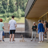 Teamspiel: Fröbelturm natur, ein spannendes Gruppenspiel aus massivem Buchenholz, wird von mehreren Personen im Freien gespielt, mit Seilen werden die Holzteile gemeinschaftlich bewegt. Ideal für 4 bis 24 Spieler.