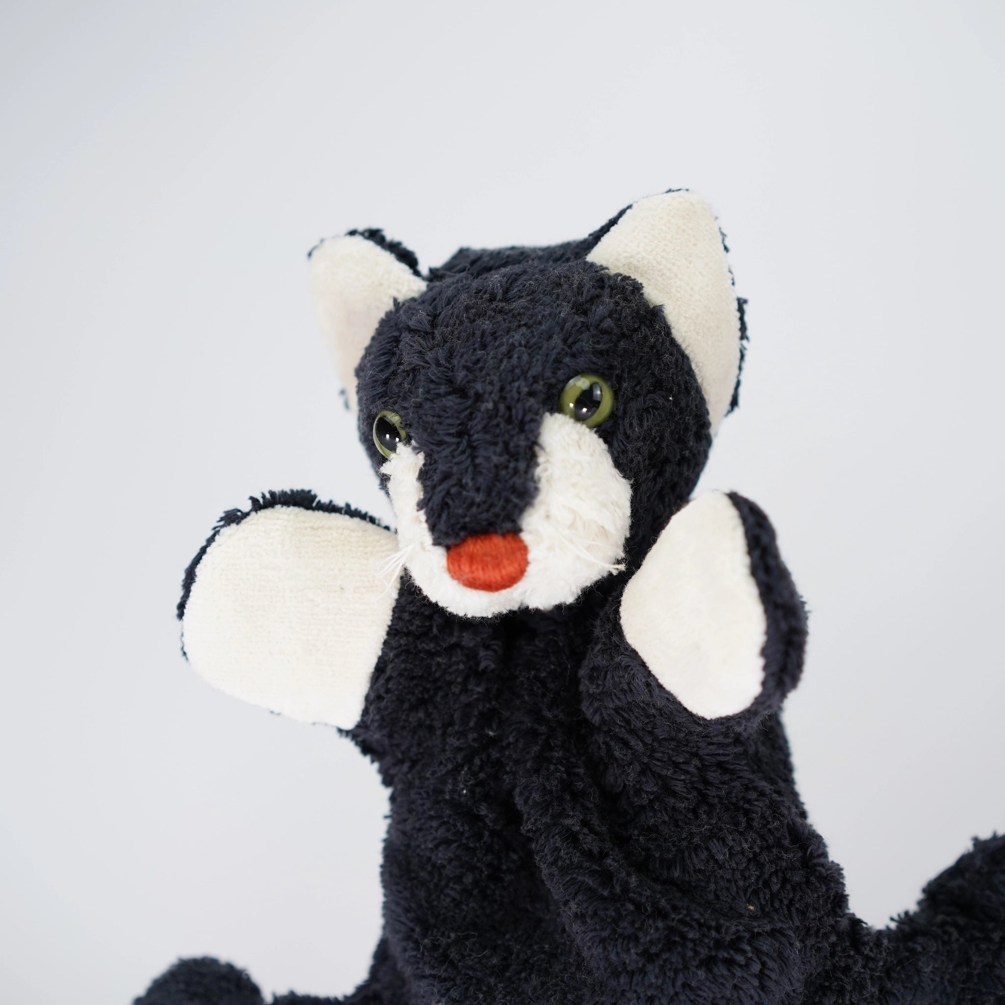 Handpuppe: Katze aus weicher Bio-Baumwolle, mit einem weißen Gesicht und grünen Augen, gefüllt mit Maiswatte. Perfekt für fantasievolle Theaterstücke, hergestellt in einer kleinen deutschen Manufaktur. Waschbar bei 30°C.