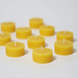 Steckfigur: Teelichter, eine Kollektion kleiner, runder Teelichter mit weißen Dochten, liebevoll hergestellt in einer deutschen Manufaktur, präsentiert auf einem schlichten weißen Untergrund.