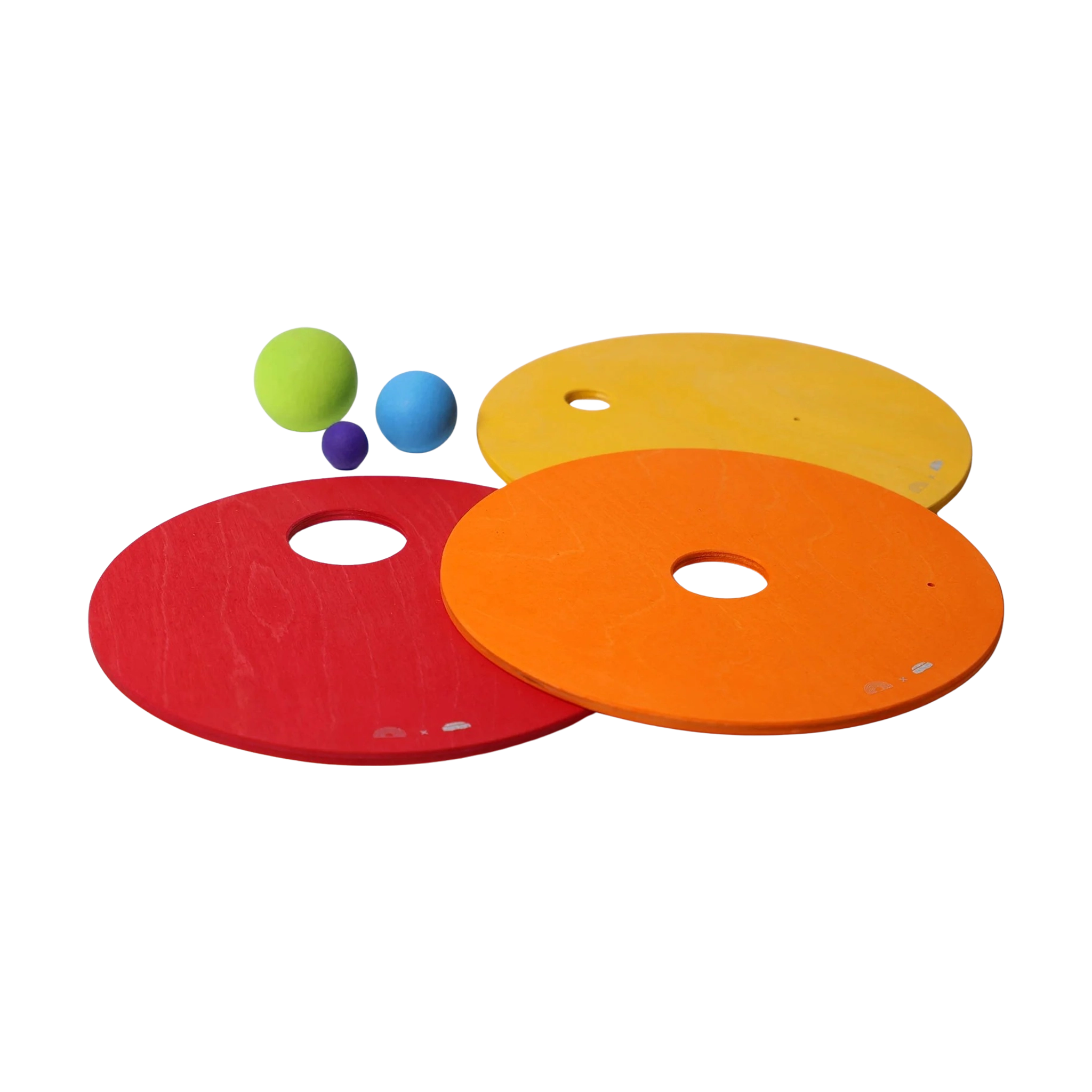 Freies Spiel: Kullerscheiben Warm Classic zeigt drei flache Holzscheiben mit zentralen Löchern und drei bunte Schaumstoffbälle darüber. Dieses Designprodukt von KLICKKLACK vereint Ästhetik, Nachhaltigkeit und Spielspaß.