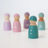 Freies Spiel: Fünf Rechenfreunde - Eine vordergründige, handbemalte Teal-Holzfigur mit weißen Knöpfen, umgeben von vier verschwommenen Figuren, symbolisiert spielerisches, nachhaltiges Lernen durch haptische Interaktion.