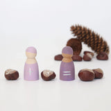 Freies Spiel: Fünf Rechenfreunde aus Holz zeigen plus und gleich Zeichen, flankiert von Kastanien als Zählobjekte. Ein spielerischer Lernansatz für erste Rechenaufgaben durch haptisches Erleben.