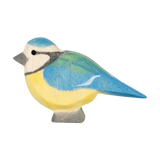Holztier: Blaumeise, eine handbemalte Ahornholzfigur, zeigt eine stilisierte Meise mit gelbem Bauch und blauen, grünen Akzenten. Perfekt für kreatives Spiel und ideal zum Kombinieren mit anderen Ostheimer Figuren.