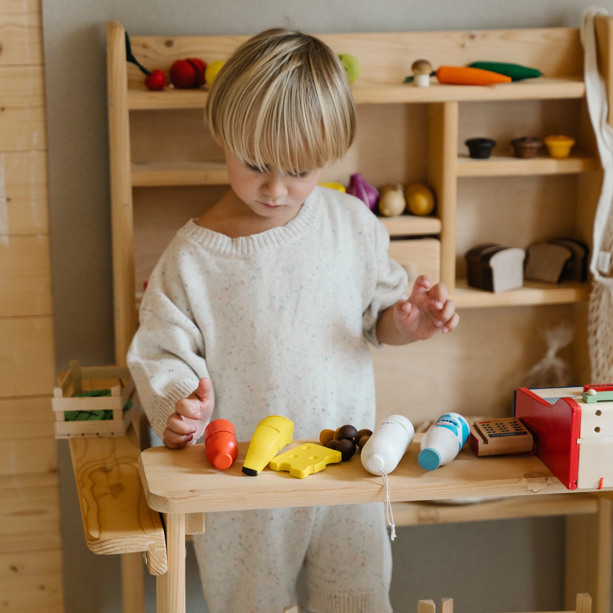 Lebensmittel: Backzutaten aus robustem Buchenholz zeigt ein Kind beim Spielen mit dem Set aus 8 Backzutaten, inklusive kleiner Holzkiste, hergestellt in einer deutschen Holzmanufaktur.