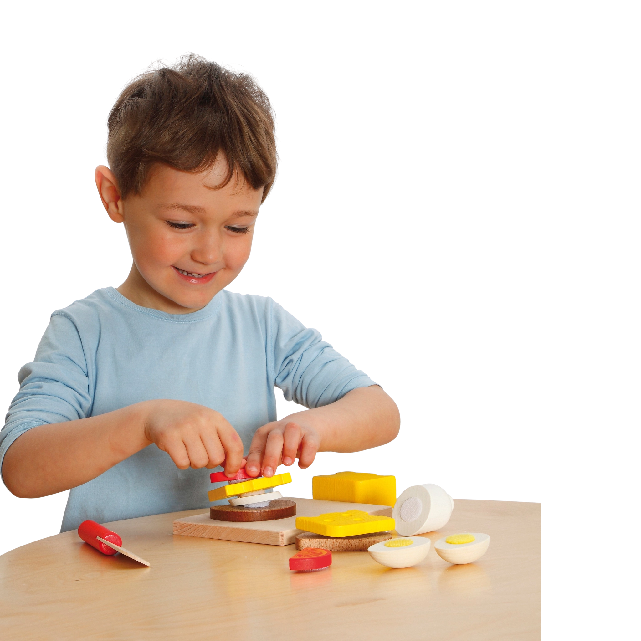 Ein Kind spielt mit dem Schneideset: Belegte Brote, gefertigt aus robustem Buchenholz, mit Klett zum Schneiden von Holzlebensmitteln, inklusive Schneidebrett und Kindermesser, hergestellt in Deutschland.