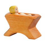 Holzfigur: Krippe mit Kind zeigt eine handbemalte, aus massivem Ahornholz gefertigte Krippe mit einer Puppe, ideal für kreatives Rollenspiel und passend zu Ostheimer Holzfiguren, hergestellt in Deutschland.