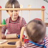 Kinderkochlöffel aus unbehandeltem Buchenholz, robust und ideal für kleine Köche. Zwei Kinder spielen fröhlich mit diesem hochwertigen Utensil, perfekt zum Mithelfen in der Küche, hergestellt in deutscher Manufaktur.