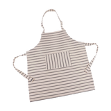 Kinderschürze aus 100 % Baumwolle, flach liegend mit dünnen dunklen Streifen, Fronttasche, Nackenschlaufe, und Bindebändern; zeitloses Design passend zur Erwachsenenschürze von Redecker, hergestellt in Deutschland.