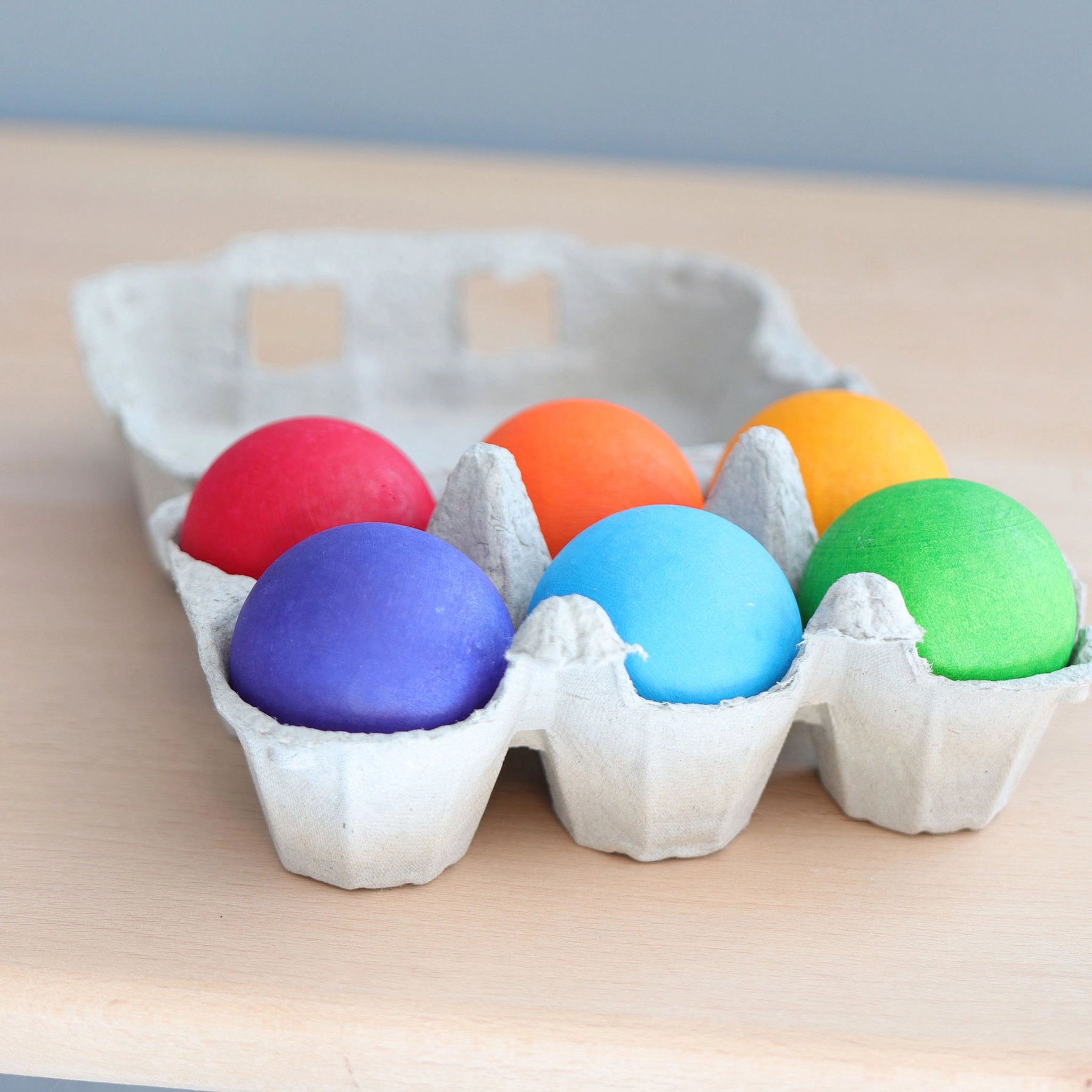 Freies Spiel: Holzkugeln Regenbogen, ein Set aus sechs bunten Holzkugeln aus Ahornholz, präsentiert auf einem Tablett. Die Kugeln sind handgefertigt in Deutschland und fördern kreatives Bauen und Sortieren.