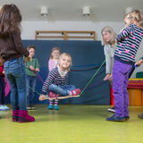 Kinder spielen mit dem Teamspiel: Strippensurfer, einem Balance- und Koordinationsspiel für Gruppen, hergestellt in Deutschland von waelderspielzeug in Zusammenarbeit mit der Karl-Schubert-Werkstätte.