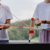 Teamspiel: Strippenzieher, ein handgefertigtes Holzspielzeug, das von mehreren Händen gehalten wird. Ideal für drinnen und draußen, fördert es Teamarbeit und soziale Interaktion für Spieler von 4 bis 99 Jahren.