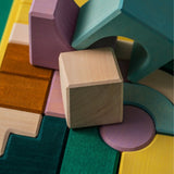 Bauwelt: Movement zeigt einen Haufen aus geometrischen Holzbausteinen in sanften Tönen, ideal für freies, kreatives Spiel. Teil von Grimm's TINY ART COLLECTION, handgefertigt in Deutschland.