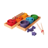 Freies Spiel: Sortierspiel Regenbogenschälchen, ein Montessori-Holzspielzeug mit zwei Tabletts, sechs bunten Schälchen und passenden Formen. Fördert Feinmotorik und Konzentration durch Sortieren und Greifen mit Holzpinzetten.