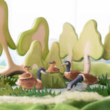 Holztier: Kanadagans stehend in einem kleinen Wald-Diorama mit handgeschnitzten Wasservögeln, stilisierten Holzbäumen, Filzgras und einem Teich, spiegelt die nachhaltige, ästhetische Philosophie von KLICKKLACK wider.