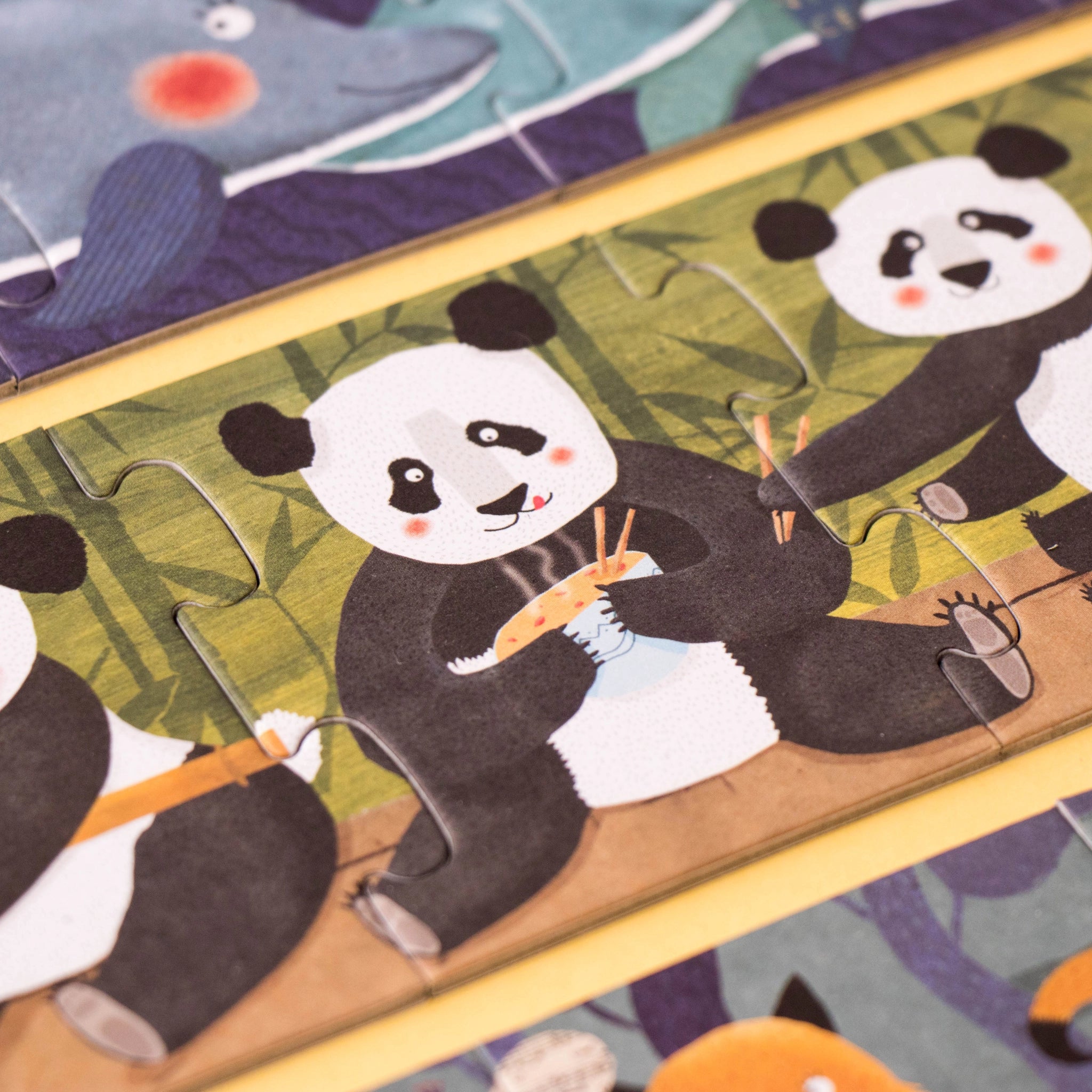 Puzzle: 10 Pinguine, ein Nahaufnahme von kindgerechten Puzzles mit Tiermotiven, illustriert mit einem Panda. Aus FSC-Papier und recyceltem Karton, ideal für spielerisches Lernen ab 3 Jahren.