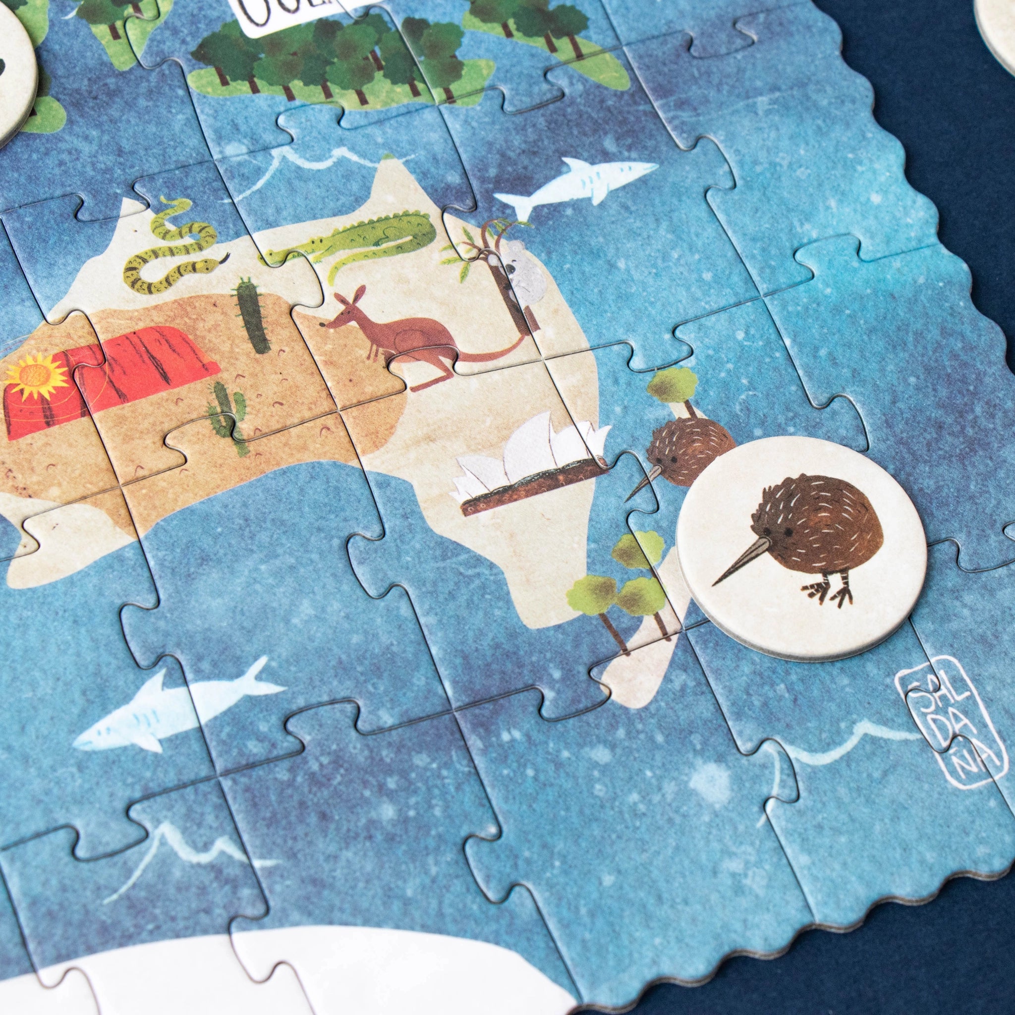 Puzzle: Entdecke die Welt – 200-teiliges Weltkarten-Puzzle mit Tiersymbolen, hergestellt aus FSC-Papier und recyceltem Karton. Enthält ein Suchspiel zu berühmten Wahrzeichen. Ideal für kleine Entdecker ab 6 Jahren.