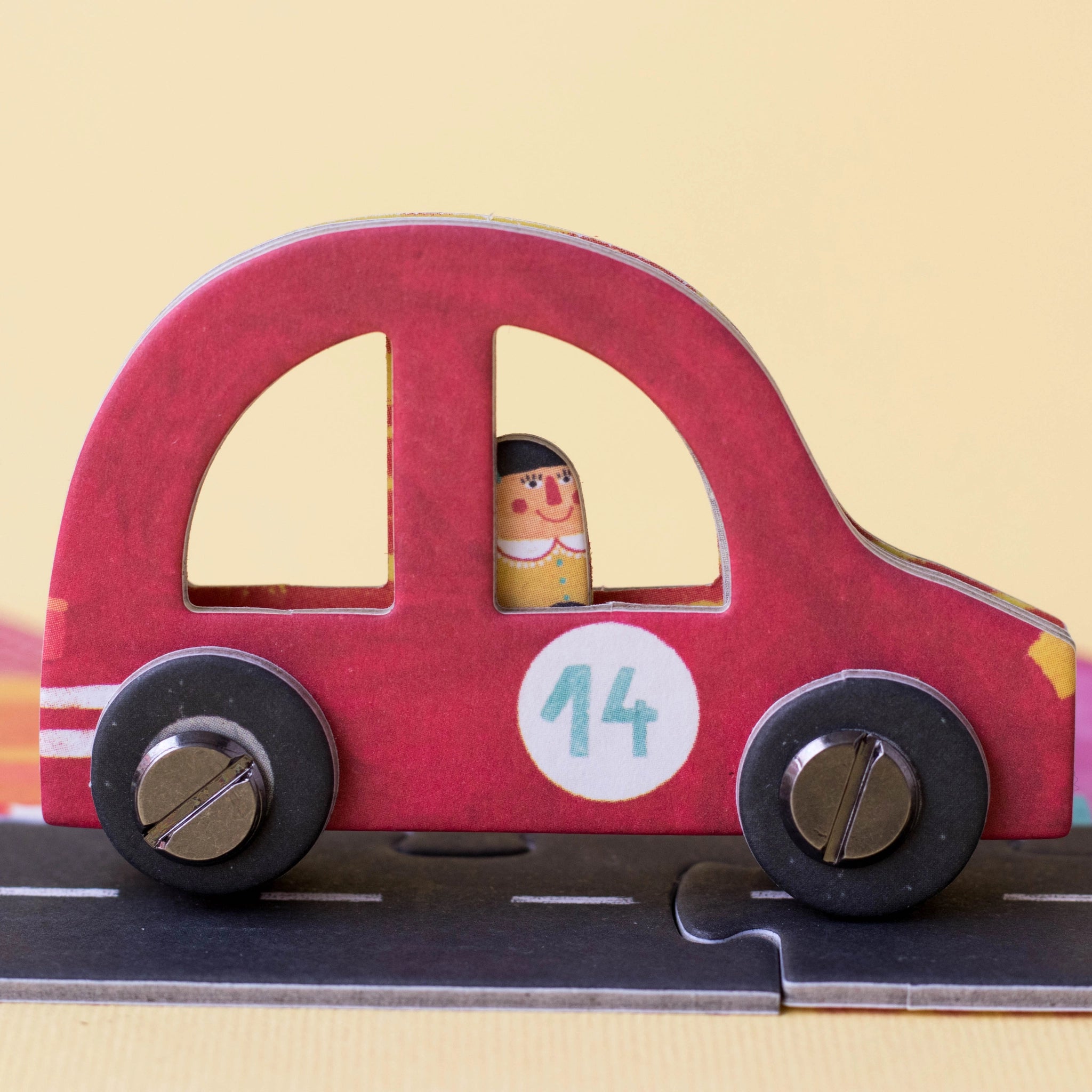 Gesellschaftsspiel: Roads – Detailaufnahme eines Spielzeugautos auf einer Straße, Teil eines kreativen Legespiels mit 6 Autos aus FSC-Papier und recyceltem Karton, hergestellt in Spanien.