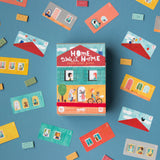 Lernspiel: Home Sweet Home – Ein Kartenstapel in einer Box auf blauem Untergrund, enthält kreative, strategiefördernde Karten mit Cartoons, für Kinder ab 7 Jahren aus recyceltem Material gefertigt.