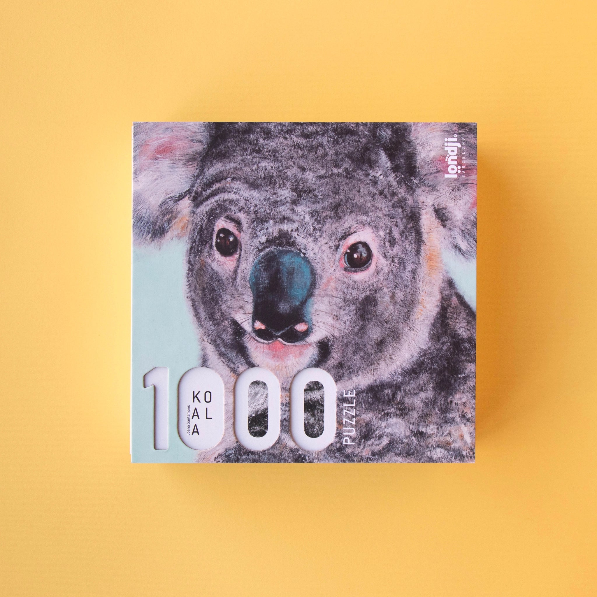 Puzzle: Koala - Ein quadratisches Puzzle mit einem Koala-Gesicht, bestehend aus 1000 Teilen, illustriert von Joana Santamans. Ideal für ältere Kinder und Erwachsene, hergestellt in Spanien aus recyceltem Material.