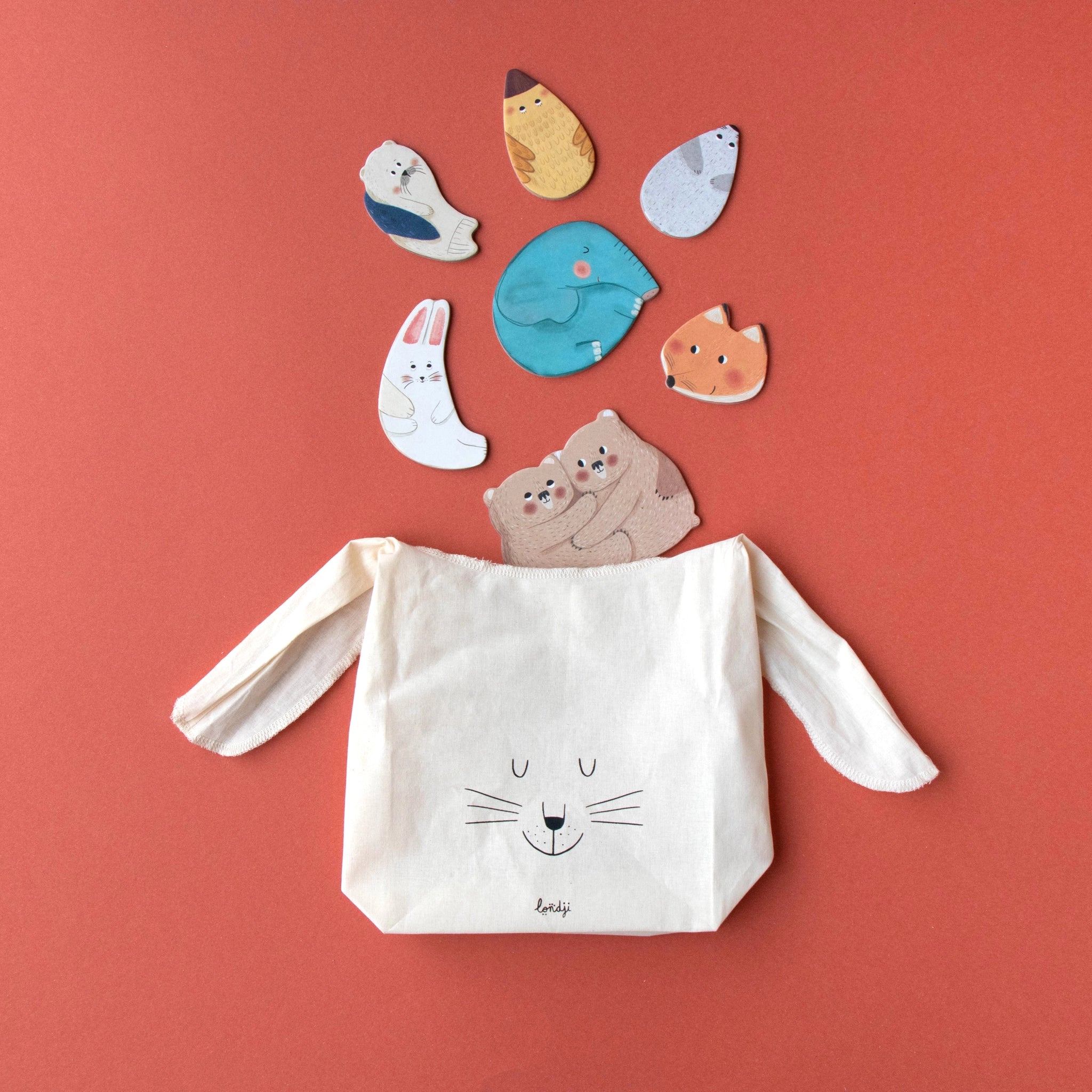 Puzzle: Mama – Eine Tasche mit Katzengesicht, aus der Vögel fliegen, symbolisiert die liebevolle Verbindung zwischen Tiermamas und ihren Babys. Nachhaltig hergestellt aus FSC-Papier und recyceltem Karton.