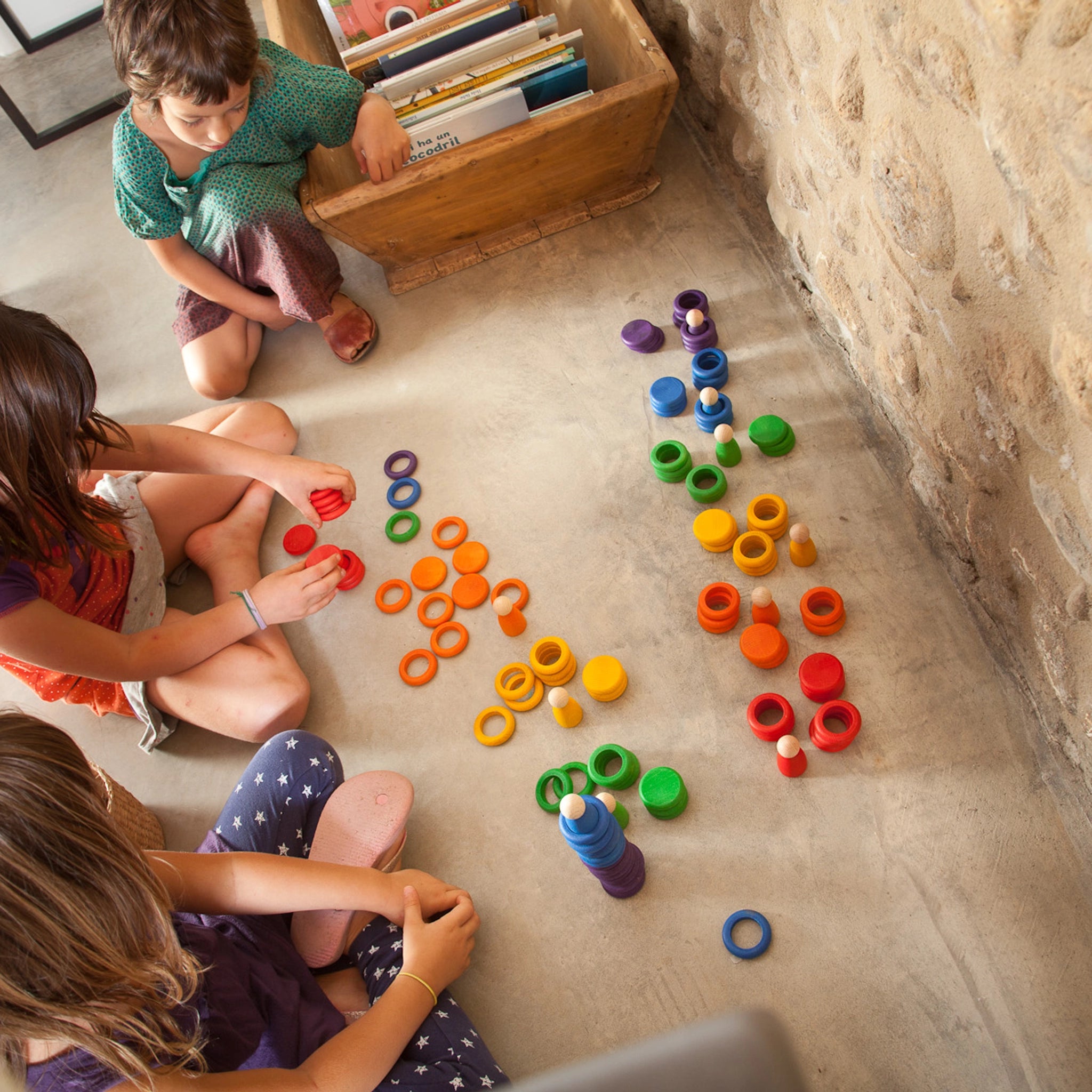 Freies Spiel: Nins, Rings & Coins aus nachhaltig geforstetem Holz. Kinder spielen mit handgefertigten Figuren, Ringen und Plättchen, ideal für kreatives Spielen. Perfekt für moderne, umweltbewusste Familien.