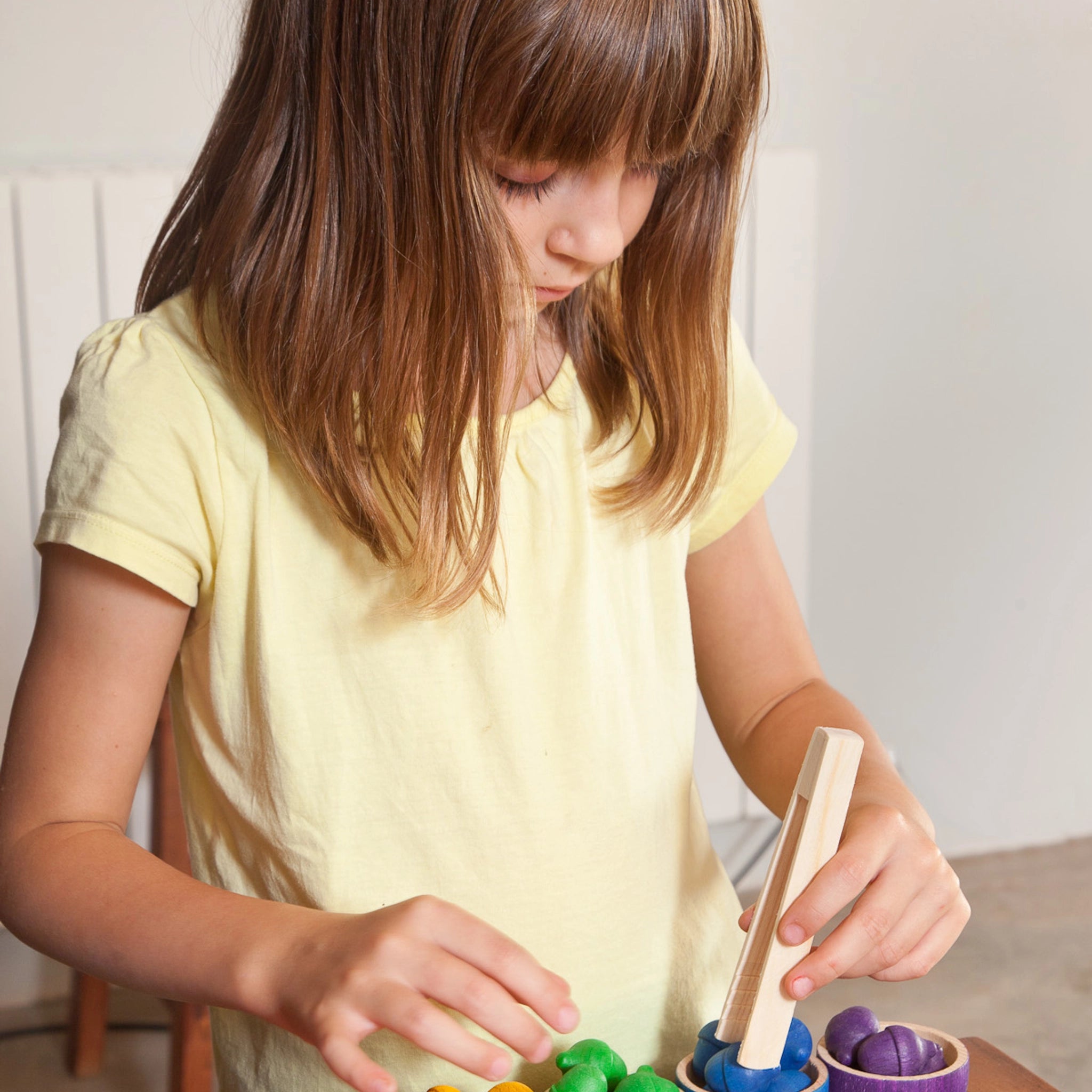 Freies Spiel: Bowls & Acorns zeigt ein Mädchen, das mit handgefertigten Holzschälchen und Eicheln spielt, ideal für kreatives Kinderspiel. Nachhaltig aus Holz, unterstützt umweltfreundliches Spielen.