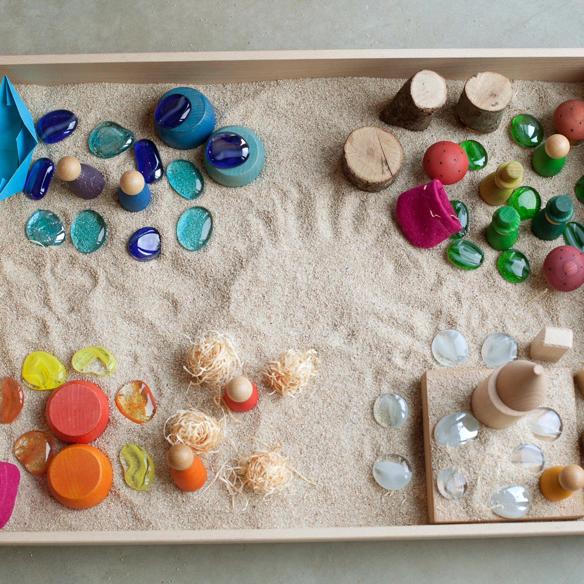 Freies Spiel: Play Box aus nachhaltig geforstetem Holz, gefüllt mit verschiedenen Naturmotiven für sensorische Erlebnisse und freies Spielen, handgefertigt in Spanien nach Montessori-Konzept, ideal für kreative Entfaltung.