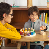 Freies Spiel: Perpetual Calendar mit einer Frau und einem Jungen, die das handgefertigte Spielset mit 12 Nins-Figuren, Tageswürfeln und Jahreskreis aus nachhaltig produziertem Holz erkunden.