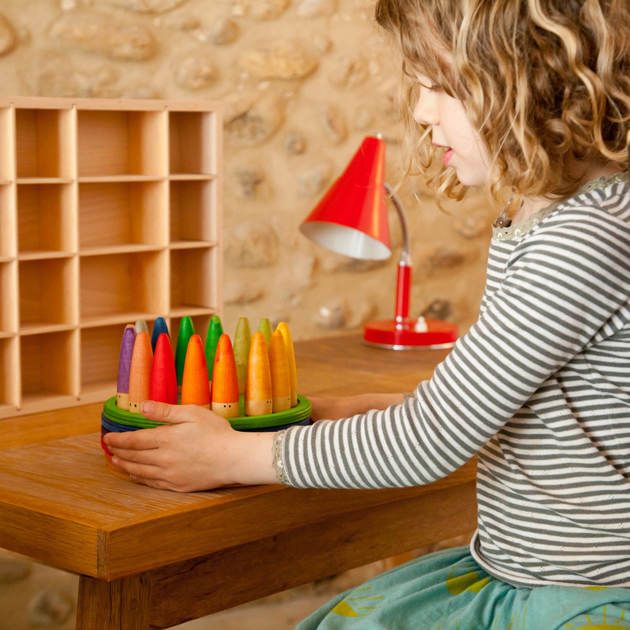 Mädchen spielt mit Freies Spiel: Sticks aus nachhaltig geforstetem Holz. Handgefertigte, dezente Figuren fördern kreatives Spiel. KLICKKLACKs Ästhetik verbindet Nachhaltigkeit mit modernem Design.