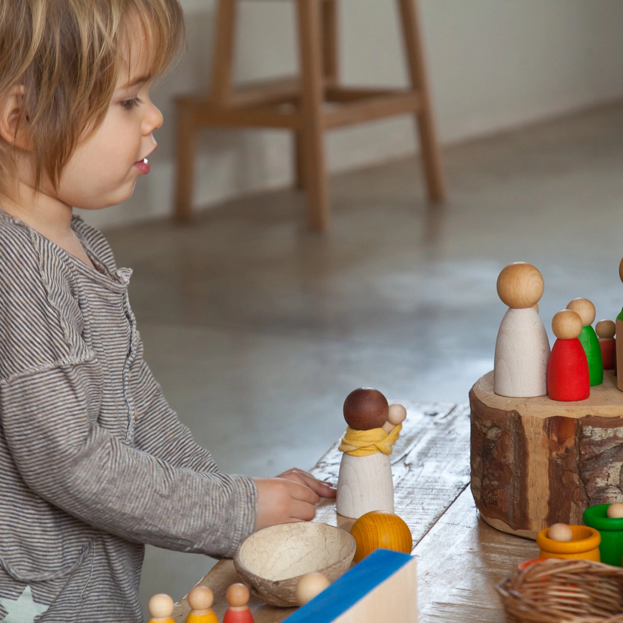 Freies Spiel: Dark Adult Nins aus dunklem Holz, handgefertigt in Spanien, ideal für kreatives Spiel. Abgebildet sind zwei Holzfiguren auf einem Baumstumpf, passend zu klassischen Nins von Grapat.