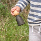 Freies Spiel: Adult Nins, handgefertigt aus nachhaltig geforstetem Holz, gehalten von einem Kind. Ideal für kreatives, freies Spiel und kombinierbar mit klassischen Nins von Grapat.