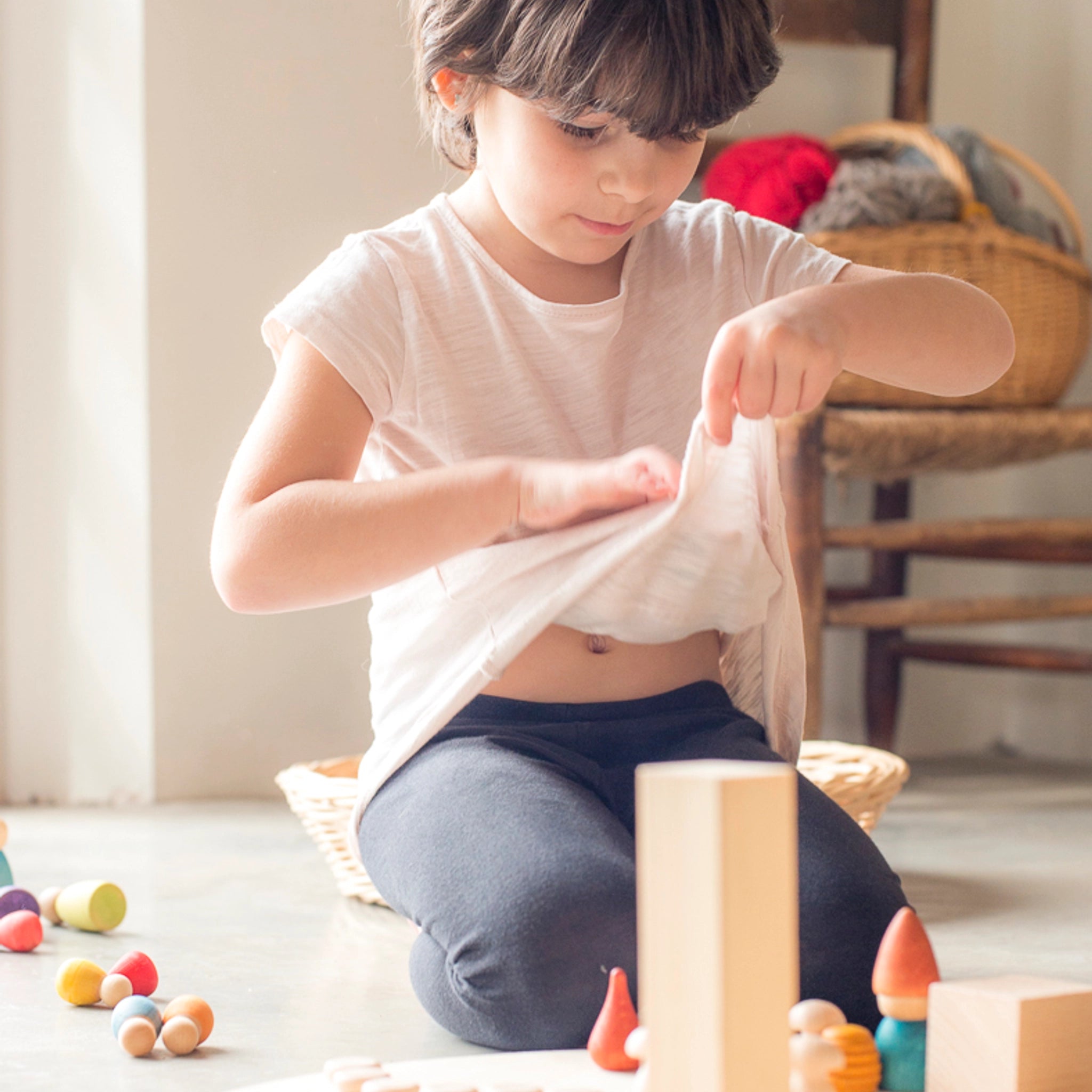 Freies Spiel: Nins Tomten – Ein Kind spielt mit handgefertigten Nins-Zwergfiguren aus nachhaltig geforstetem Holz, begleitet von passendem Wichtelzubehör, ideal für kreatives Spiel.