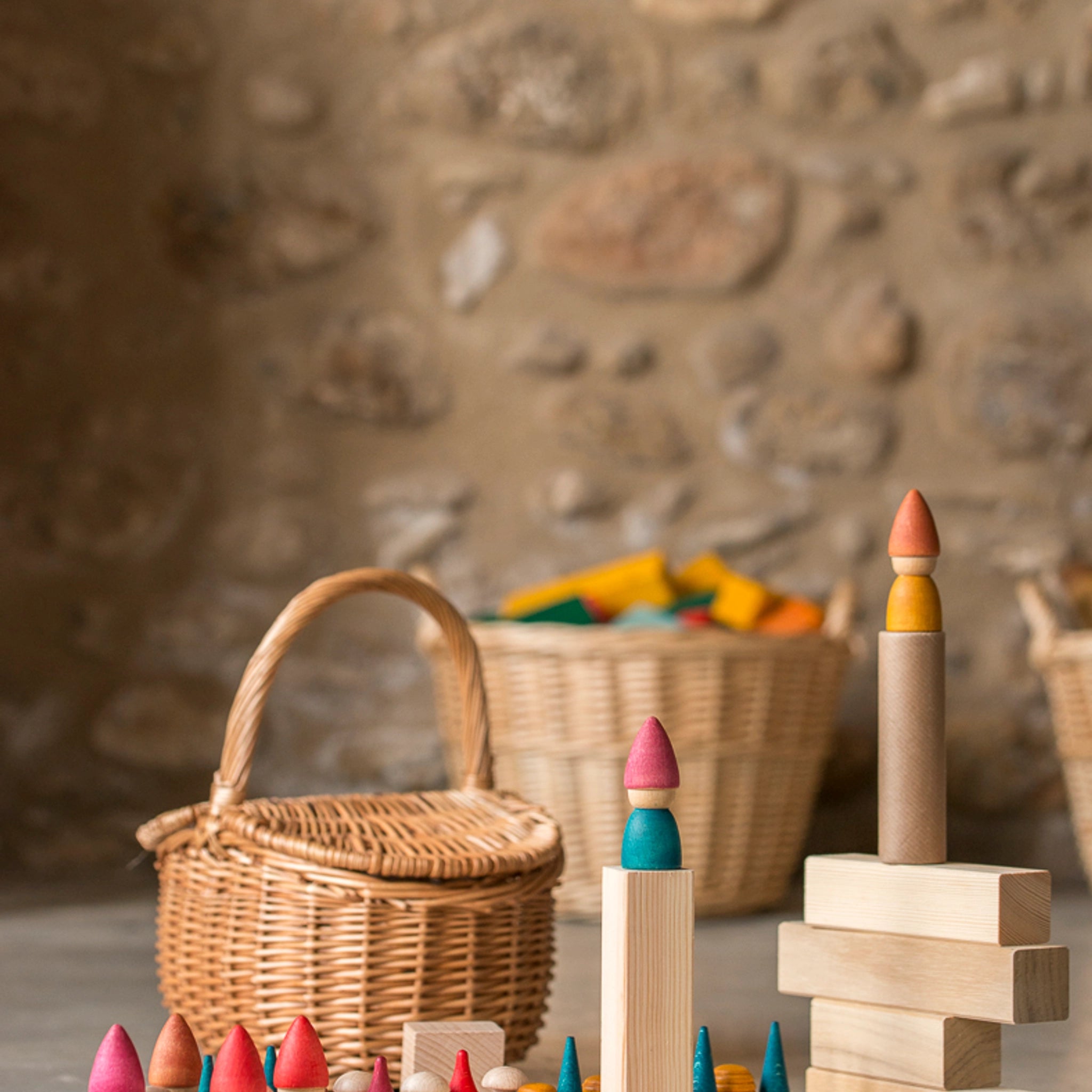 Freies Spiel: Nins Tomten, ein Set aus handgefertigten Holzfiguren und passendem Wichtelzubehör in einem Korb, ideal für kreatives Kinderspiel, präsentiert die nachhaltige Ästhetik von KLICKKLACK.