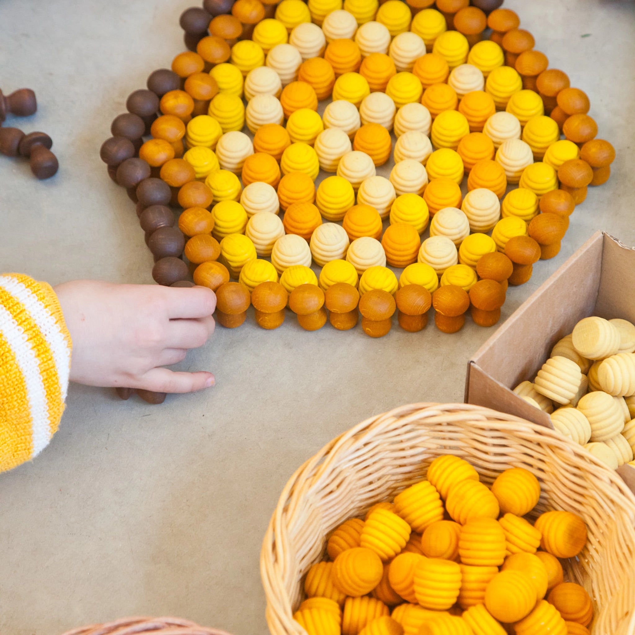 Freies Spiel: Mandala Honeycomb – Kinderhand berührt handgefertigte Holz-Honigwaben, ideal für kreatives Spiel und Mandalas. Nachhaltig produziert, fördert es ästhetische Gestaltung und soziale Fairness.