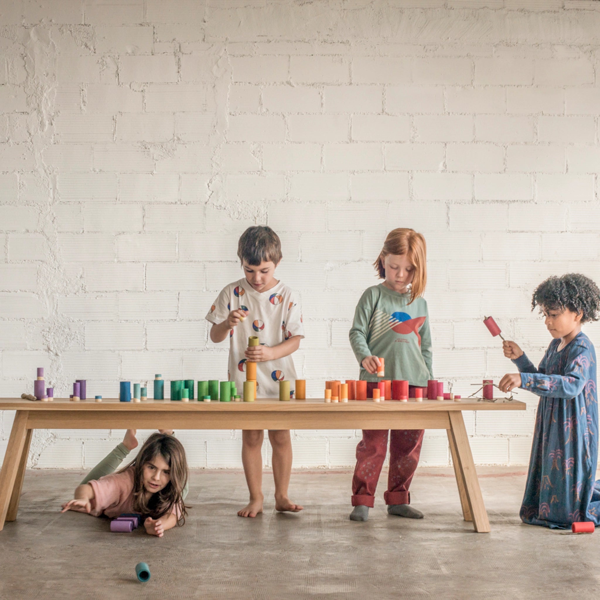 Kinder spielen mit Freies Spiel: Lola, einem handgefertigten Set aus nachhaltig produziertem Holz mit 72 Teilen, das ideal für kreatives Spielen geeignet ist.