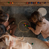 Kinder spielen mit den Freies Spiel: Mandala Rainbow Eggs, einem Set aus 36 handgefertigten, regenbogenfarbenen Holzeiern, ideal für kreatives Spielen und das Gestalten von Mandalas und Kunstwerken.