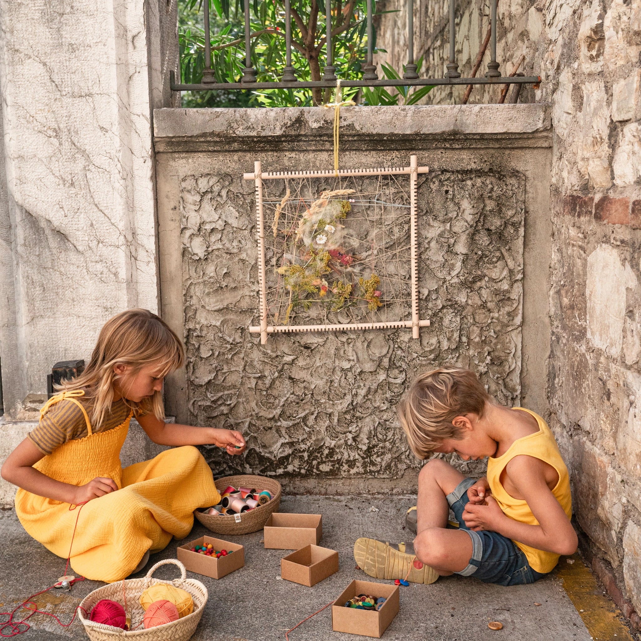 Freies Spiel: Rahmen zum Weben und Präsentieren, handgefertigt aus nachhaltig geforstetem Holz. Geeignet für kreatives Spielen, mit Blumen und Fäden verziert, ideal für Kinder.