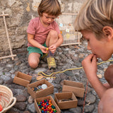 Zwei Kinder spielen mit dem Freies Spiel: Frame aus nachhaltig geforstetem Holz, ideal zum Weben und kreativen Spiel. Handgefertigt in Spanien, fördert es freies Spielen und Kreativität.