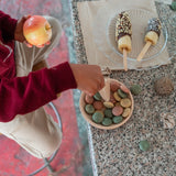 Freies Spiel: Yummy - Handgefertigtes Set aus Holz mit 2 Löffeln, 1 Teller und 24 köstlichen Nachbildungen. Perfekt für fantasievolles Spiel, abgebildet auf einem Tisch mit Snacks und Desserts auf Sticks.