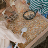 Kinder spielen mit dem Freies Spiel: Tools Set aus nachhaltig produziertem Holz, bestehend aus sechs handgefertigten Werkzeugen, ideal für kreatives Spiel drinnen und draußen.