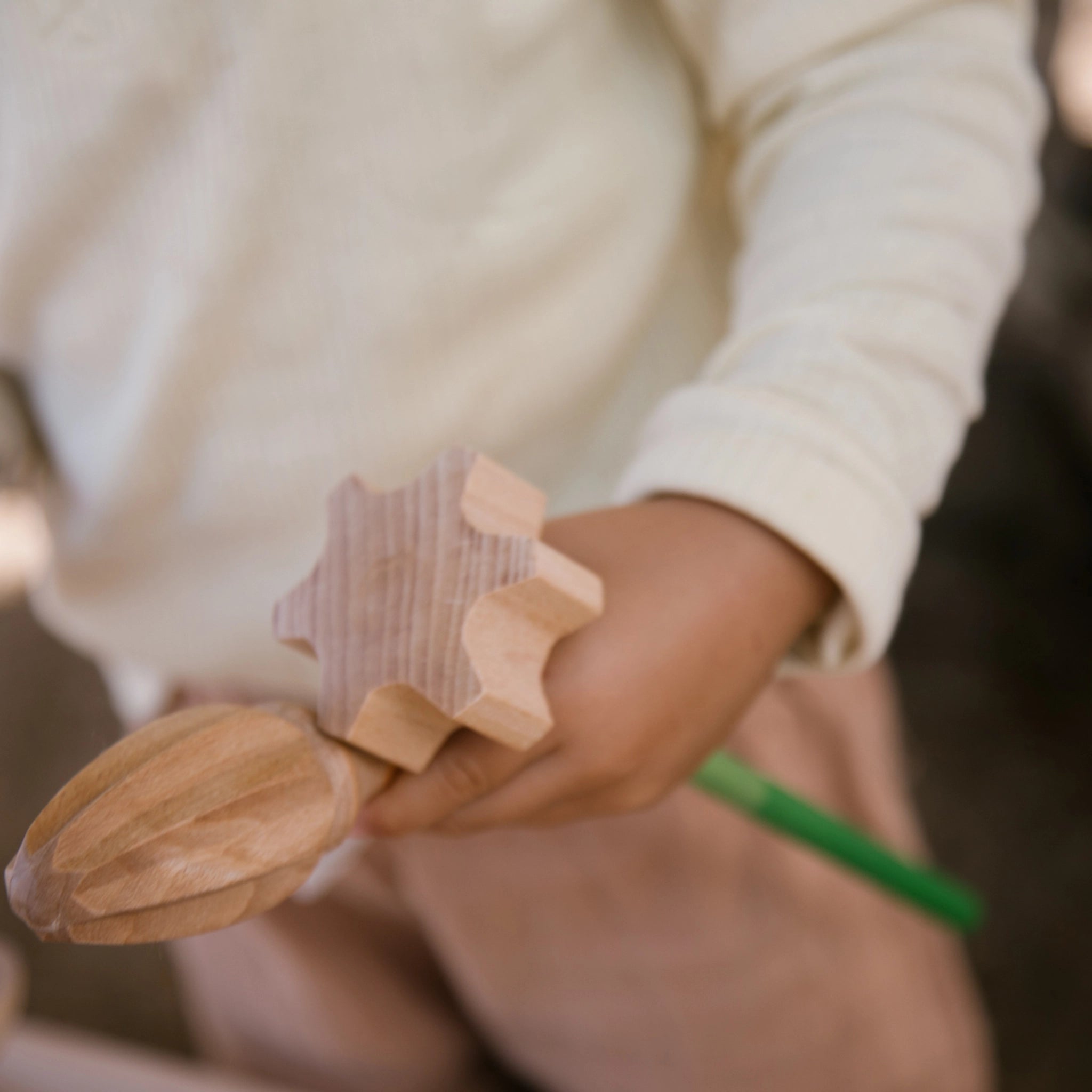 Freies Spiel: Tools – Ein Kind hält ein handgefertigtes Holzwerkzeug, das Teil eines Sets aus nachhaltig produziertem Holz ist, ideal für kreatives Spielen drinnen und draußen, erhältlich bei KLICKKLACK.