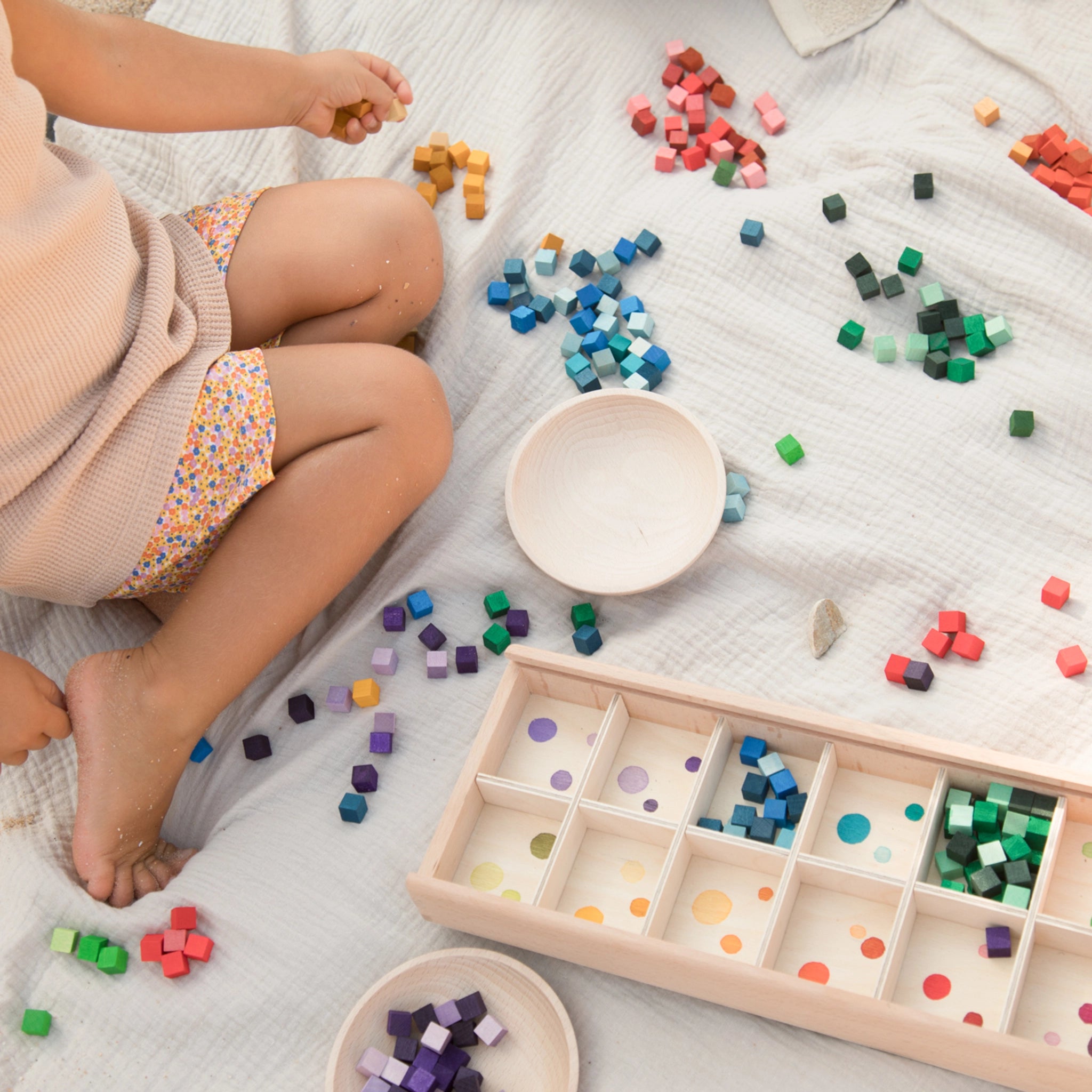 Freies Spiel: Mis and Match - Ein Kind spielt mit einem handgefertigten Setzkasten aus nachhaltigem Holz, gefüllt mit über 400 bunten Holzwürfeln, ideal für kreatives, freies Spiel.