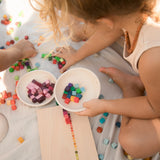 Freies Spiel: Mis and Match - Zwei Kinder spielen mit über 400 handgefertigten Holzwürfeln aus nachhaltigem Anbau, präsentiert in einem Setzkasten, ideal für kreatives, freies Spiel, hergestellt in Spanien.