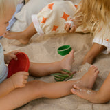 Freies Spiel: Pots aus nachhaltig geforstetem Holz, handgefertigt in Spanien. Kinder spielen mit den bunten Töpfchen im Sand, ideal für kreatives Spielen drinnen und draußen.