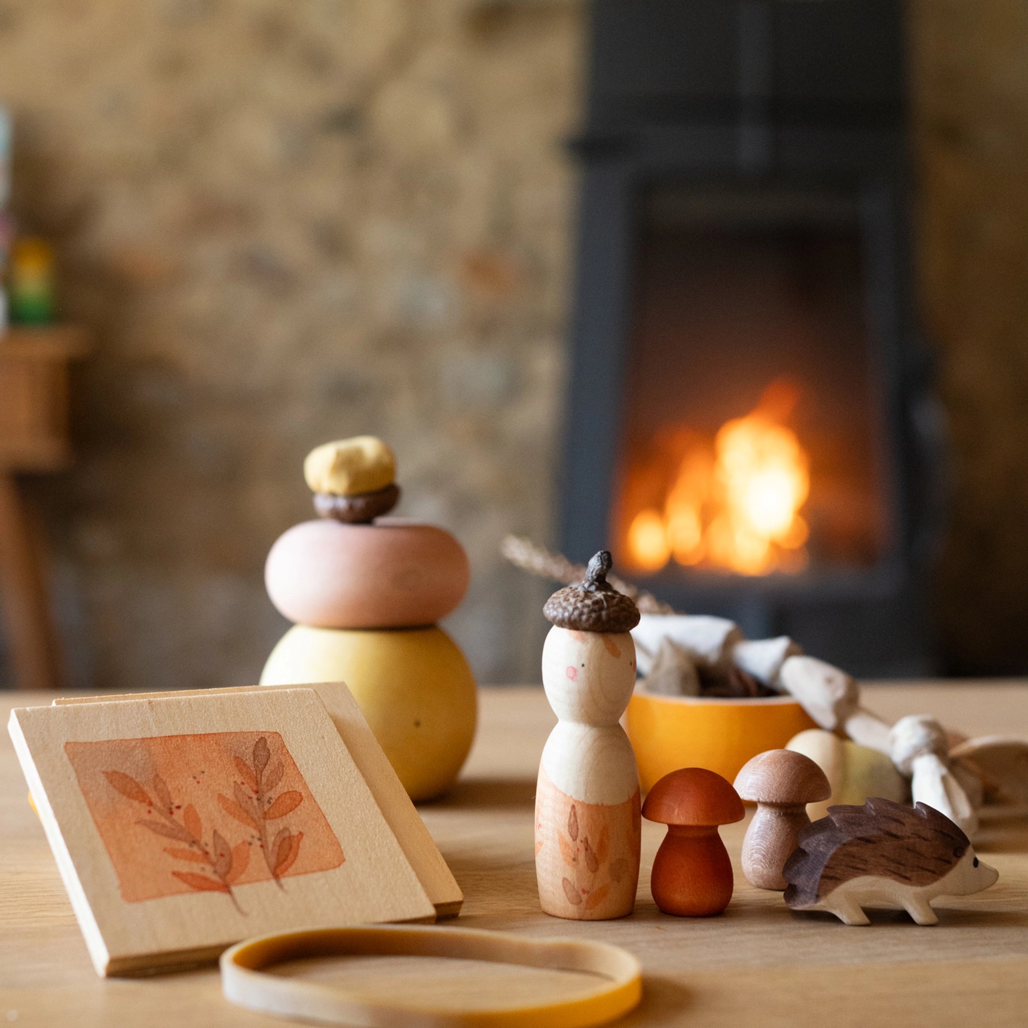 Freies Spiel: Hello autumn! präsentiert ein handgefertigtes Set aus nachhaltigem Holz mit Blattmotiv-Rahmen, pastellfarbenem Stapelspielzeug, Peg-Doll, Pilzen und Igel, inspiriert von der Natur für kreative Herbstabenteuer.